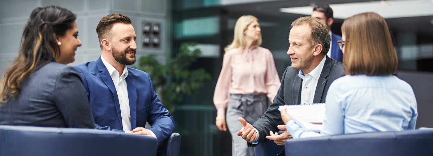 Teambesprechung mit Kollegen in einer Sitzgruppe